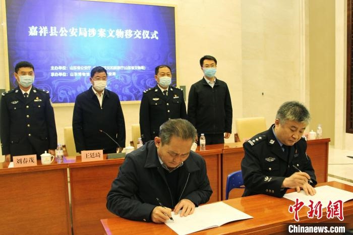 山東博物館館長鄭同修和嘉祥縣人民政府副縣長、公安局局長趙健簽署移交協(xié)議。　趙曉 攝