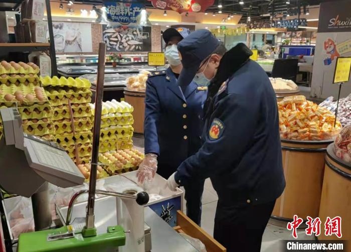 圖為疫情期間，甘肅嘉峪關市場監(jiān)管局工作人員檢查蔬菜市場?！?柴佳楠 　攝