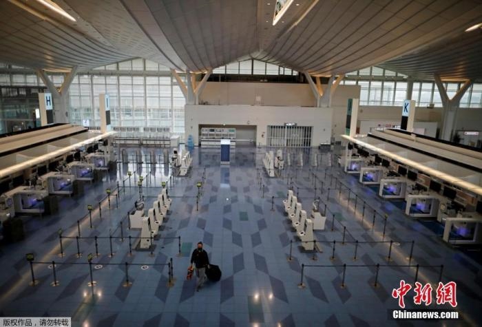 資料圖：日本東京，東京國際機(jī)場，一名乘客在國際航班航站樓的登機(jī)區(qū)。