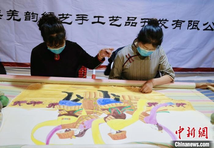 圖為皮繡藝人在市集上“秀”指尖技藝。　馬銘言 攝