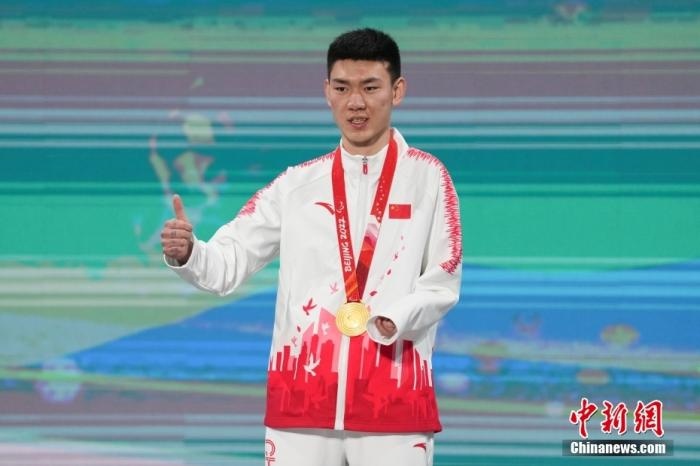 3月6日，梁景怡在延慶頒獎(jiǎng)廣場領(lǐng)獎(jiǎng)臺上豎起大拇指。當(dāng)日，在國家高山滑雪中心舉行的北京2022年冬殘奧會殘奧高山滑雪男子超級大回轉(zhuǎn)—站姿決賽中，中國選手梁景怡奪得冠軍。 <a target='_blank' href='/'>中新社</a>記者 楊華峰 攝