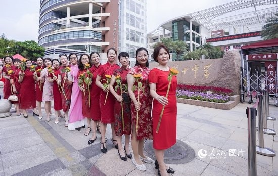 6月7日一早，廈門(mén)雙十中學(xué)考生家長(zhǎng)們身穿旗袍，手拿向日葵在考場(chǎng)外為孩子加油打氣，寓意“旗開(kāi)得勝，一舉奪魁”。人民網(wǎng)記者 陳博攝