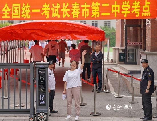 6月7日，在長(zhǎng)春市第二中學(xué)考點(diǎn)，一名考生信心滿(mǎn)滿(mǎn)進(jìn)入考場(chǎng)，并與家長(zhǎng)揮手致意。人民網(wǎng)記者 李洋攝