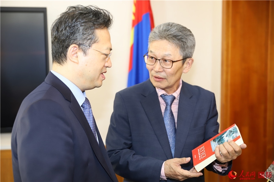 其米德策耶（右一）向李峙介紹翻譯成果。人民網(wǎng)記者 霍文攝