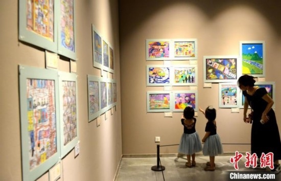 圖為家長(zhǎng)帶著孩子參觀展覽。呂明 攝