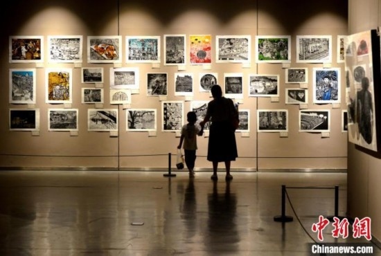 圖為家長(zhǎng)帶著孩子參觀展覽。呂明 攝