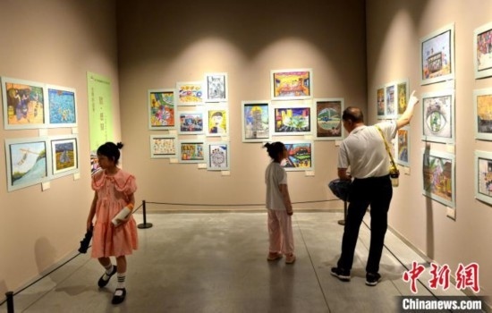 圖為家長(zhǎng)帶著孩子參觀展覽。呂明 攝