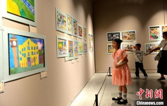 圖為家長(zhǎng)帶著孩子參觀展覽。呂明 攝