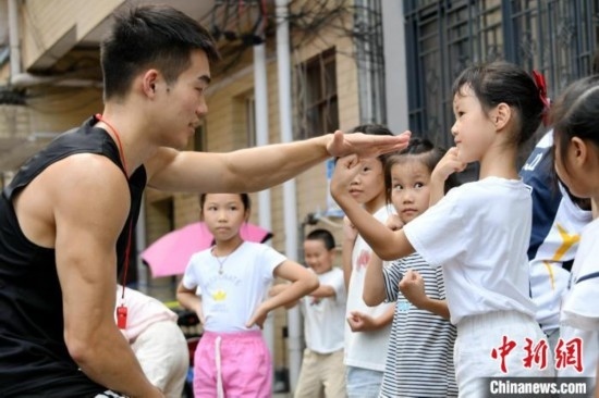 圖為大學(xué)生志愿者在組織孩子們參加體育健身活動(dòng)。廖光福 攝