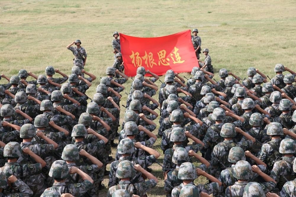 ↑“楊根思連”官兵執(zhí)行任務(wù)前向連旗宣誓（資料照片）。新華社發(fā)