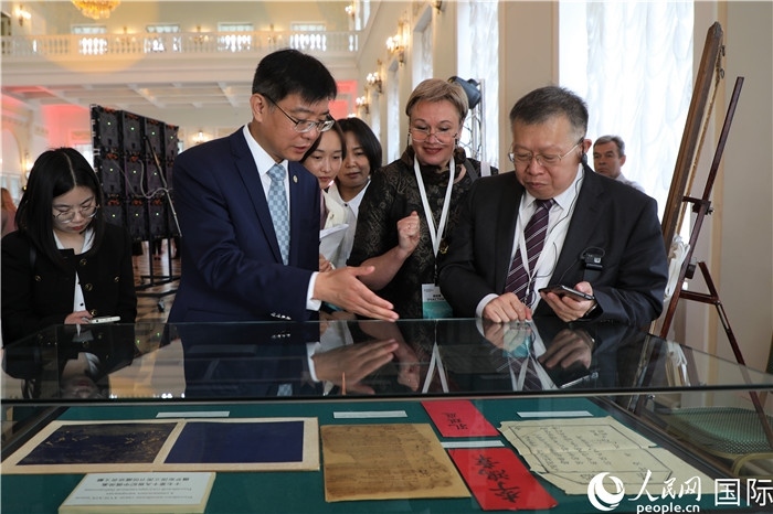 中俄圖書館論壇嘉賓共同參觀由俄羅斯國(guó)立列寧圖書館舉辦的館藏中國(guó)古籍善本圖書展。人民網(wǎng)記者 隋鑫攝）