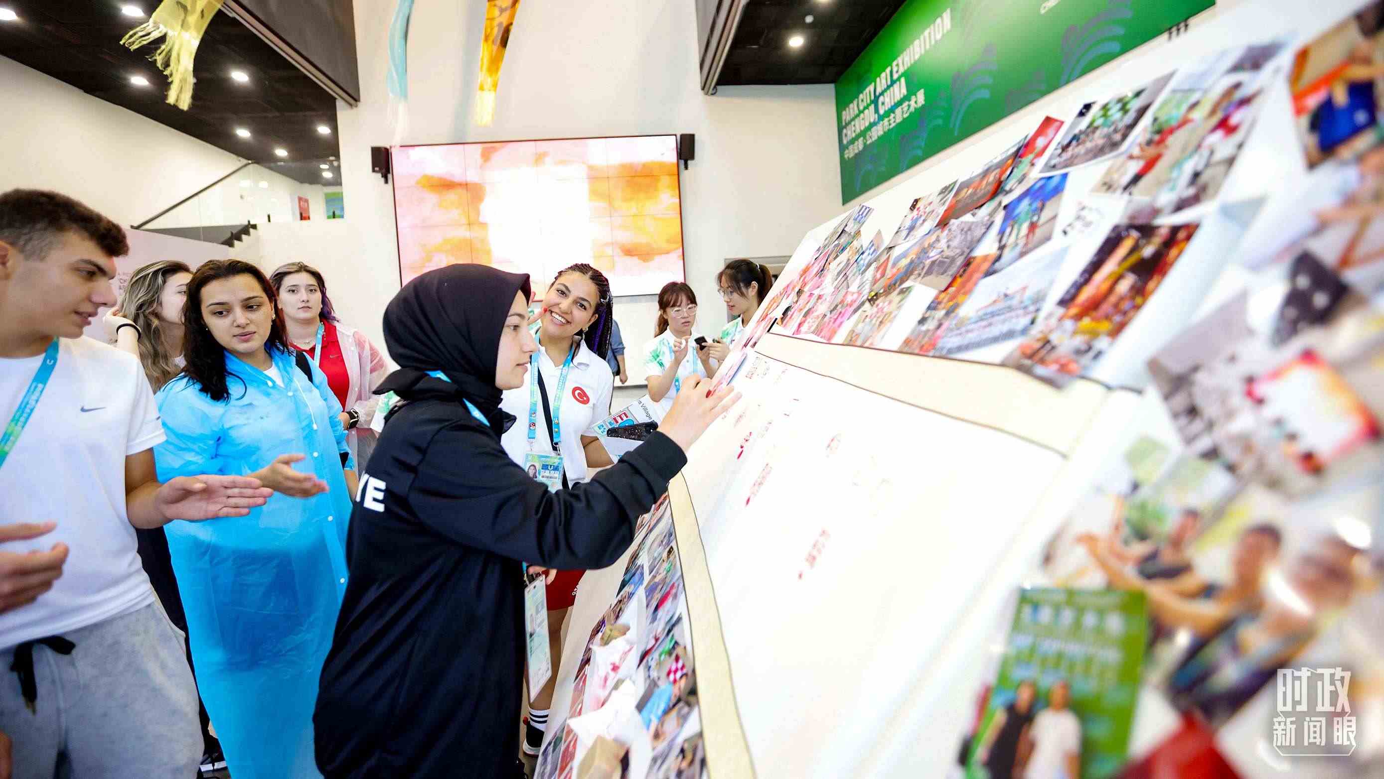各國青年運動員正在參觀成都大運村內(nèi)的“雪山下的公園城市，煙火里的幸福成都”主題藝術(shù)展。（總臺央視記者魏幫軍拍攝）