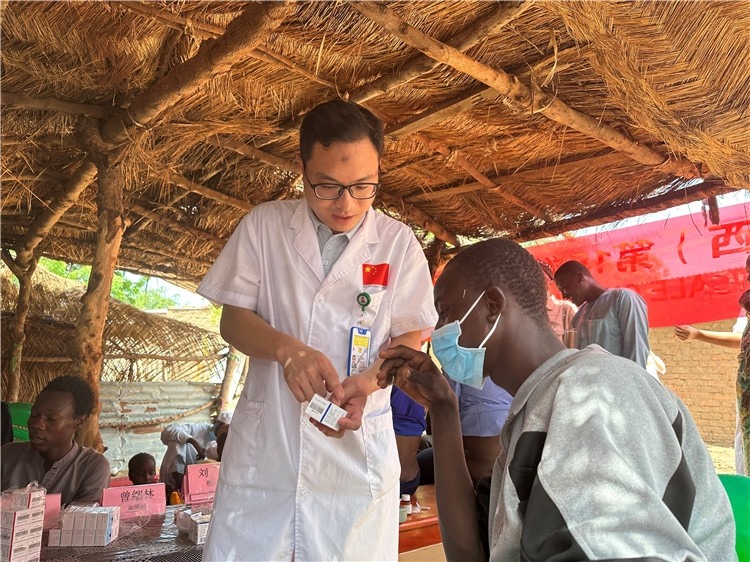 圖為南昌大學(xué)第一附屬醫(yī)院病理科主治醫(yī)師張振東為村民解說(shuō)藥品使用方法。中國(guó)駐乍得醫(yī)療隊(duì)供圖
