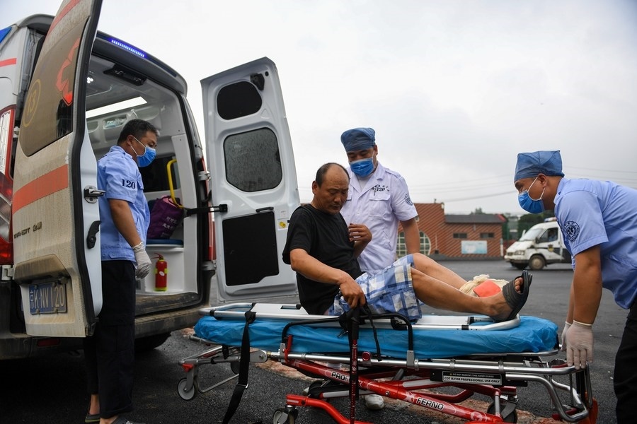 8月1日，在北京市門頭溝區(qū)妙峰山鎮(zhèn)妙峰山民族學(xué)校臨時(shí)安置點(diǎn)，北京急救中心工作人員在轉(zhuǎn)運(yùn)一名受傷村民。新華社記者 鞠煥宗 攝