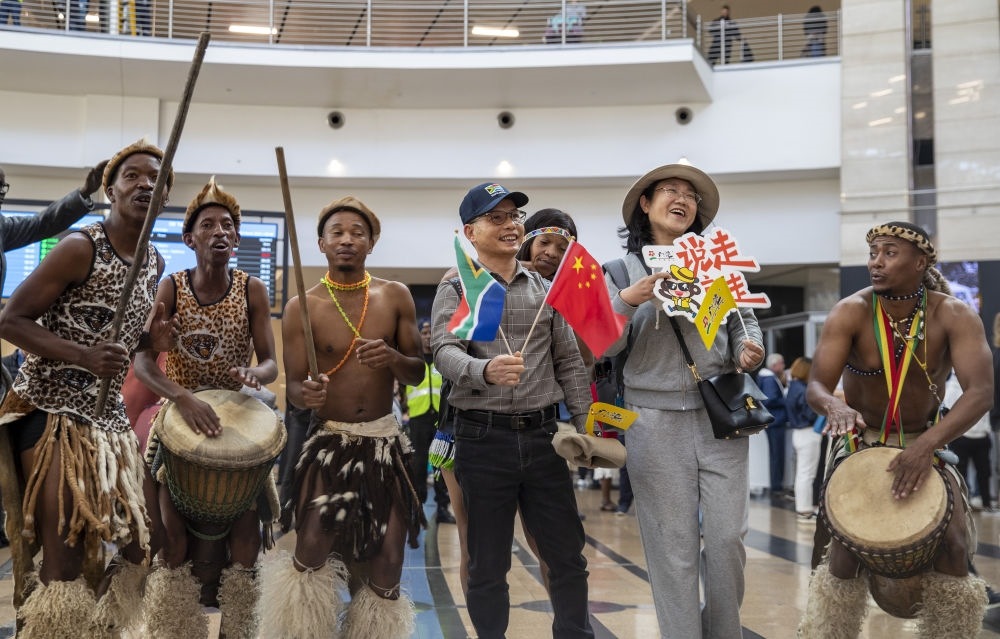 在南非約翰內(nèi)斯堡坦博國際機場，南非舞蹈演員歡迎中國試點恢復(fù)出境團隊旅游后首批抵達南非的中國游客（2023年3月29日攝）。