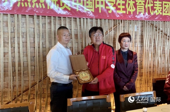 巴西中國和平統(tǒng)一促進會會長王俊曉向中國中學(xué)生體育代表團團長劉立新贈送紀念品。人民網(wǎng)記者 宋亦然攝