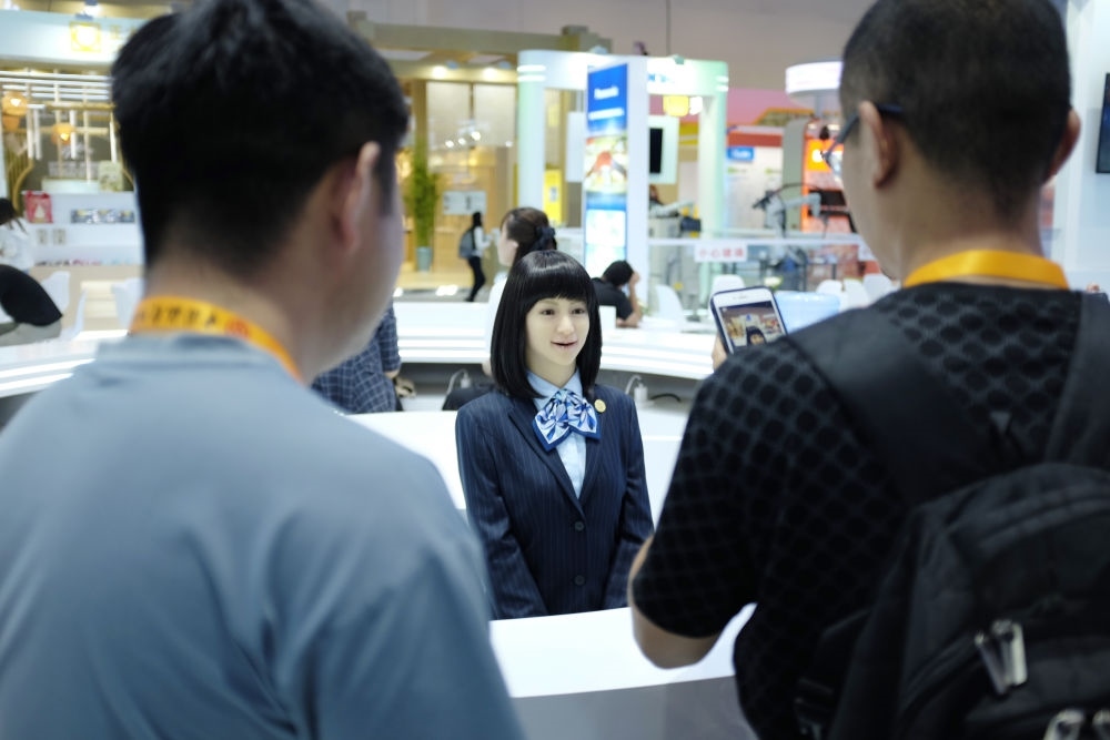 9月1日，媒體記者在國家會議中心與服務(wù)機器人互動。新華社記者 劉夢琪 攝