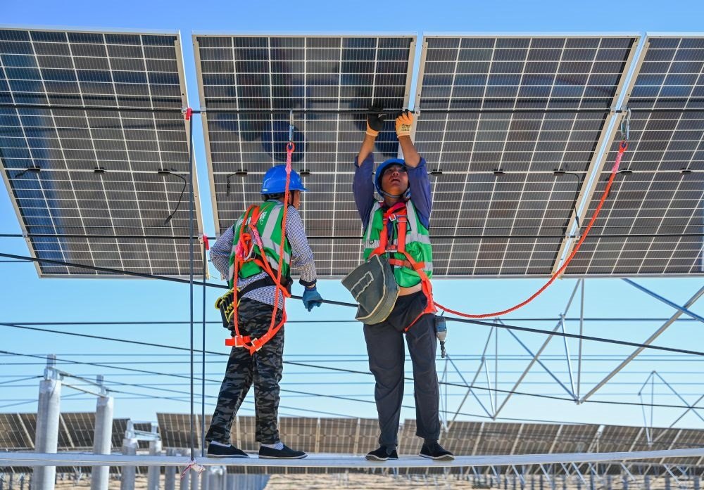 2023年7月22日，工人在位于內(nèi)蒙古杭錦旗庫布其沙漠億利生態(tài)示范區(qū)的蒙西基地庫布其200萬千瓦光伏治沙項目工地安裝光伏板。新華社記者 劉磊 攝