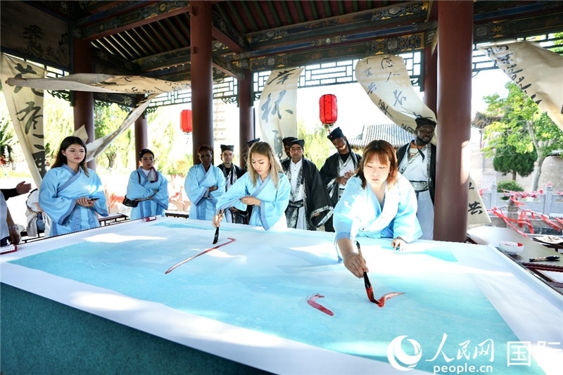 選手們提筆書寫“家園”二字。人民網(wǎng) 盧鵬宇攝