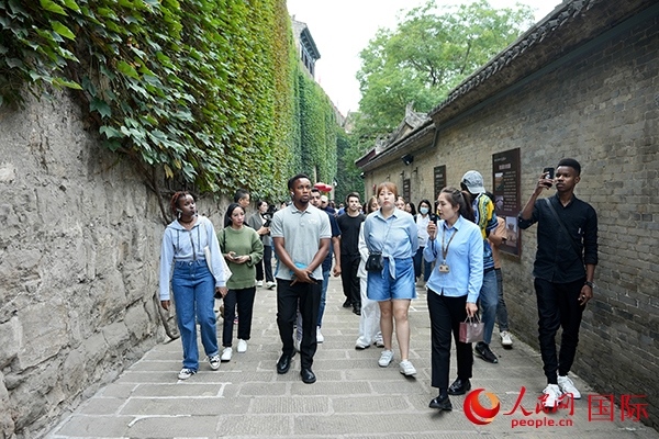 選手們認真聆聽導游講解。人民網(wǎng) 盧鵬宇攝