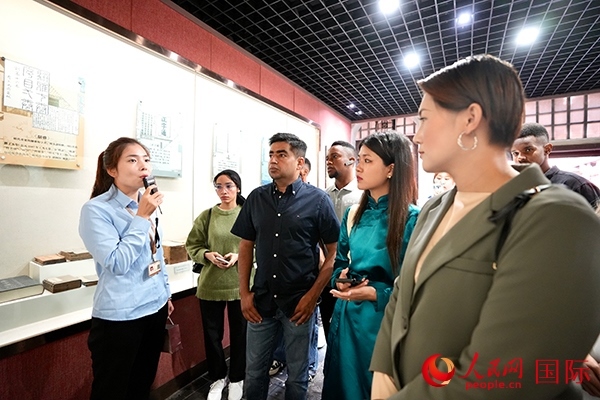 選手們認真聆聽導游講解。人民網(wǎng) 盧鵬宇攝