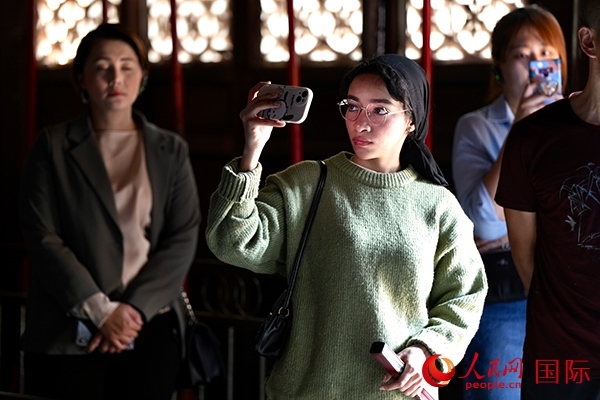 選手顏青（蘇丹）用手機記錄所見所感。人民網(wǎng) 盧鵬宇攝