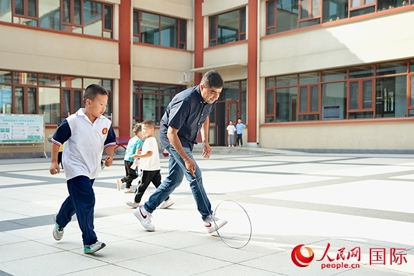 來(lái)自巴基斯坦的沙杰在滾鐵環(huán)。人民網(wǎng) 盧鵬宇攝