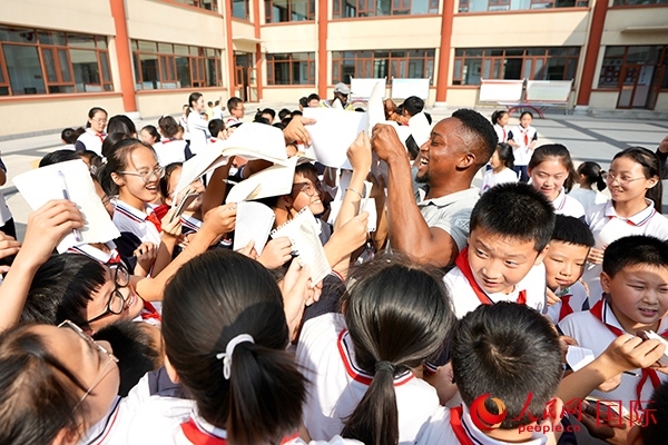 孩子們和選手互動(dòng)簽名。人民網(wǎng) 盧鵬宇攝