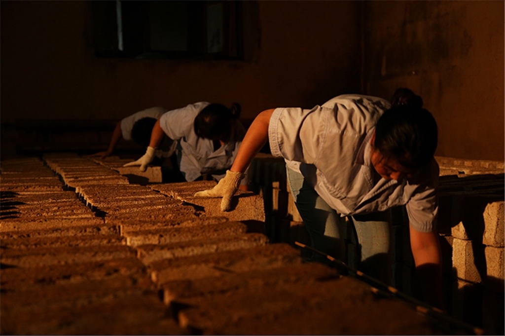 匠人師傅正在翻動曲胚。張?zhí)炝z