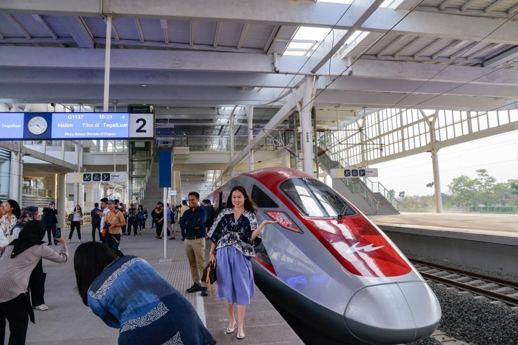 10月17日，在印度尼西亞萬(wàn)隆德卡魯爾站，乘客在站臺(tái)上和雅萬(wàn)高鐵高速動(dòng)車(chē)組列車(chē)合影。