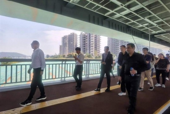 10月24日，2023“一帶一路”媒體合作論壇聯(lián)合采訪團團員走在清水塘大橋景觀通道上。本報記者 常雯宜攝