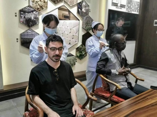 2023“一帶一路”媒體合作論壇聯(lián)合采訪團(tuán)團(tuán)員在九牛草展示館體驗(yàn)艾灸。（本報(bào)記者 黃超攝）