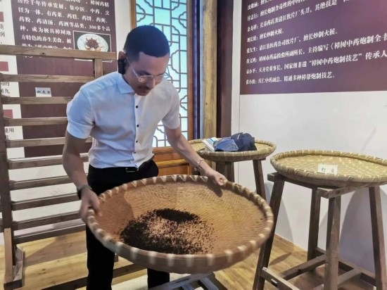 2023“一帶一路”媒體合作論壇聯(lián)合采訪團(tuán)團(tuán)員在非遺文化展示館體驗(yàn)中藥炮制技藝。（本報(bào)記者 黃超攝）