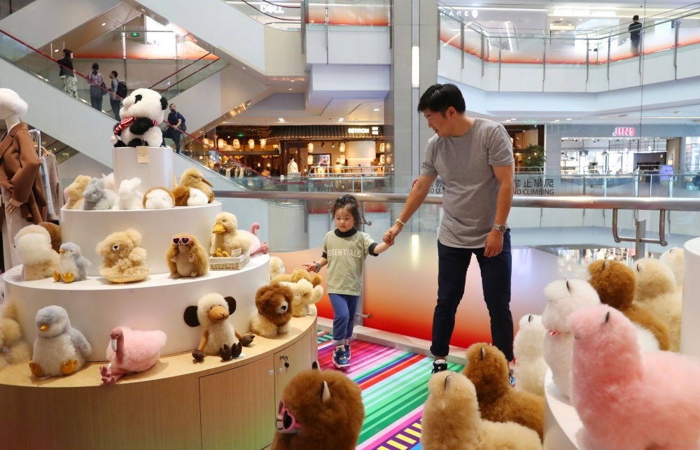 2023年11月2日，顧客在溫暖駝品牌專柜內(nèi)選購。連續(xù)六年參加進(jìn)博會(huì)的秘魯羊駝制品品牌溫暖駝在上海市中心商場開設(shè)了專柜。新華社記者 方喆 攝