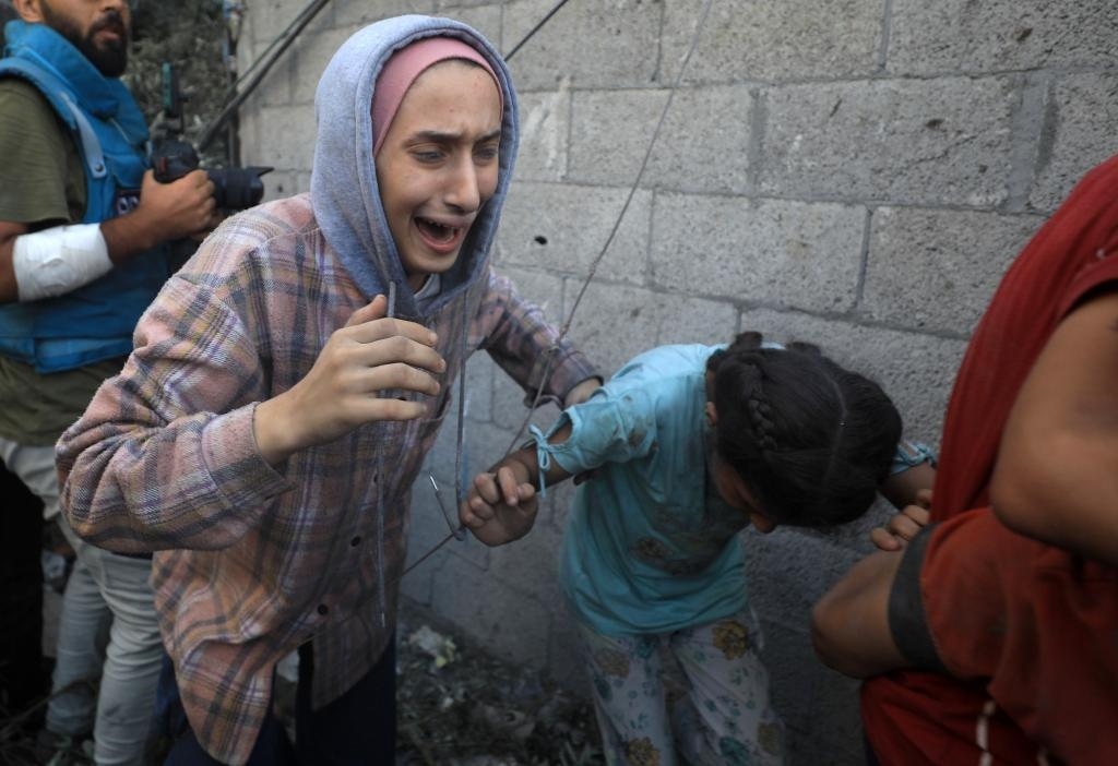 11月6日，人們從加沙地帶中部地區(qū)一處被炸難民營逃離。新華社發(fā)（亞西爾·庫迪攝）