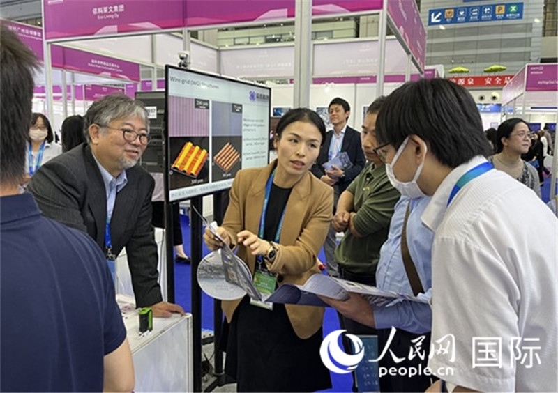 工作人員向參觀者介紹超級噴墨技術(shù)。（人民網(wǎng)記者 陳思攝）