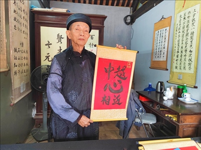 越南首都河內(nèi)文廟內(nèi)，阮明珠展示“中越心相近”書法作品。