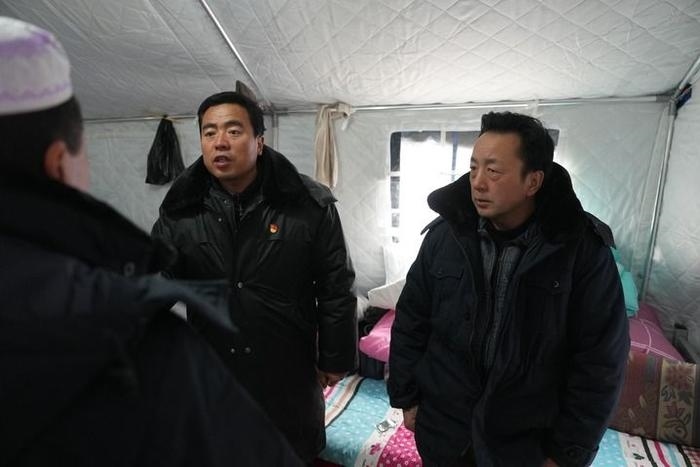 2023年12月22日，積石山縣大河家鎮(zhèn)大河村黨支部書記馬成忠（右二）在帳篷里和受災(zāi)群眾交流。新華社記者 陳斌 攝