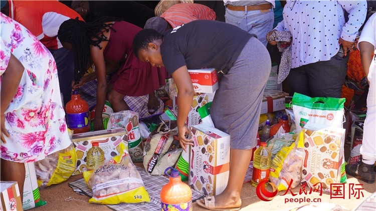 當(dāng)?shù)厣鐓^(qū)家庭領(lǐng)取物資。人民網(wǎng) 張茜攝