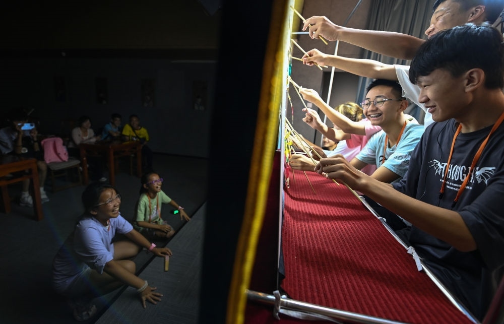 2023年8月8日，進行暑期研學(xué)的學(xué)生在位于陜西省西安市的中國秦腔藝術(shù)博物館體驗皮影戲演出。新華社記者 鄒競一 攝