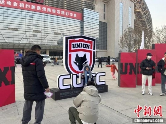 球迷們與隊(duì)徽合影。記者 卞立群 攝