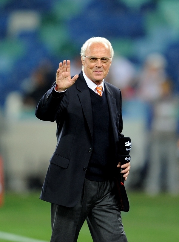 這是2010年7月7日，在南非德班舉行的2010年足球世界杯德國隊(duì)對(duì)陣西班牙隊(duì)的半決賽前，貝肯鮑爾接受電視臺(tái)采訪時(shí)和友人打招呼。新華社記者 王毓國 攝