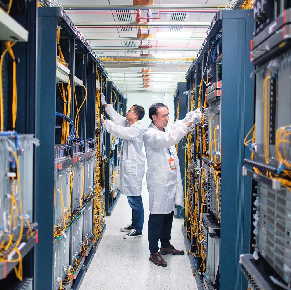 在位于武漢中國光谷的光電器件研發(fā)制造商——武漢光迅科技股份有限公司生產(chǎn)車間內(nèi)，技術(shù)人員在光模塊生產(chǎn)線作業(yè)（2023年4月11日攝）。程敏攝/本刊