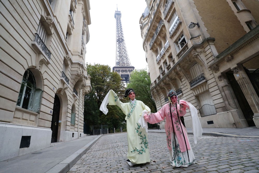 2023年9月13日，江蘇省演藝集團(tuán)昆劇院院長施夏明（左）和江蘇省演藝集團(tuán)昆劇院國家一級(jí)演員孔愛萍在法國巴黎埃菲爾鐵塔附近參加昆曲快閃。新華社記者 高靜 攝