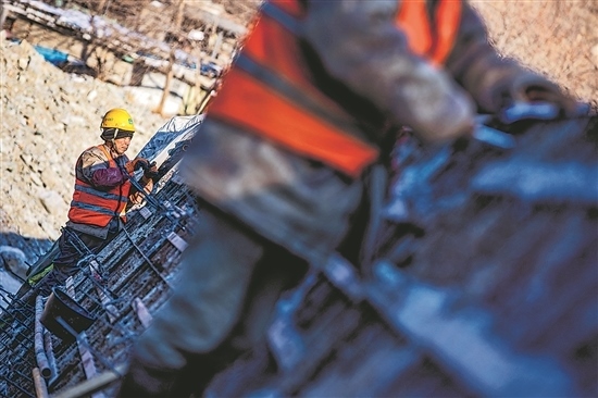 1月3日，房山區(qū)，工人正在雙泉河修筑堤壩。