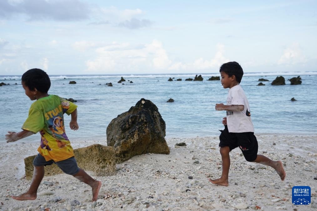 1月20日，兒童在瑙魯海邊嬉戲。新華社記者 王申 攝
