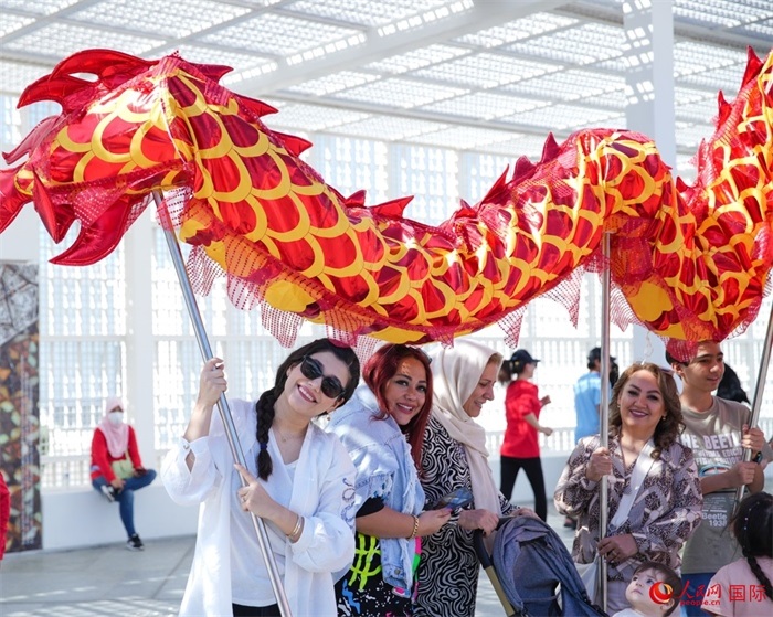 游客體驗舞龍。 人民網(wǎng) 塔里克·易卜拉欣攝