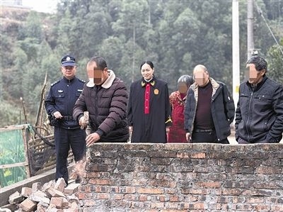  圖③：庭審結束后，在法官的見證下，陳某在院壩邊重新開鑿一條通道。