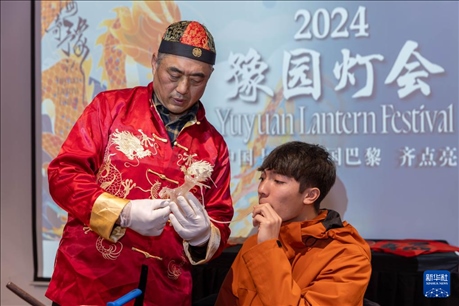 1月28日，在上海豫園舉行的民俗活動上，美國馬斯卡廷中學學生在非遺傳承人的指導下吹糖偶。 新華社記者 王翔 攝