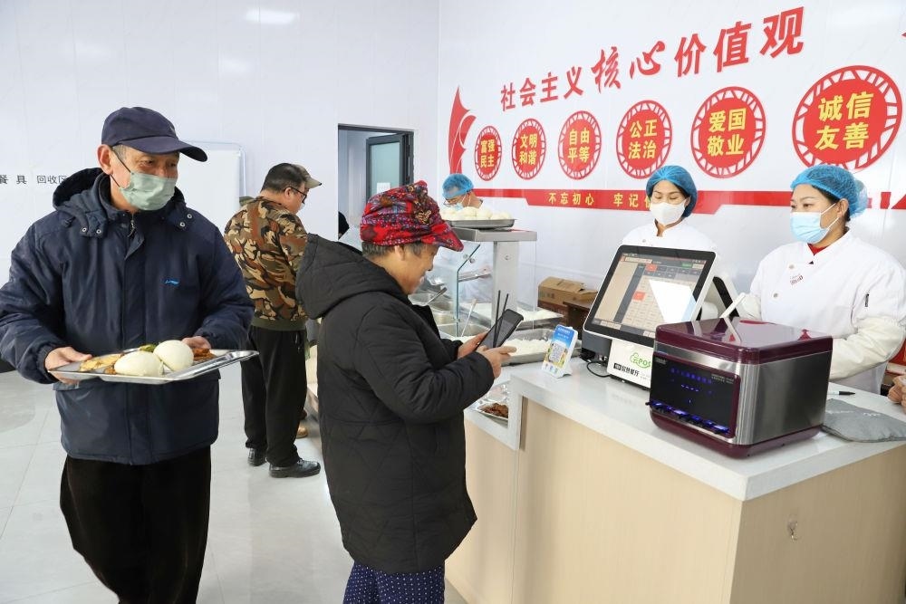 △2024年2月1日，市民在河北涿州市雙塔街道永濟(jì)秀園小區(qū)便民食堂內(nèi)購買午餐。